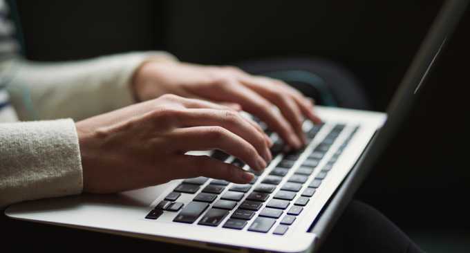Pair of hands typing on a laptop